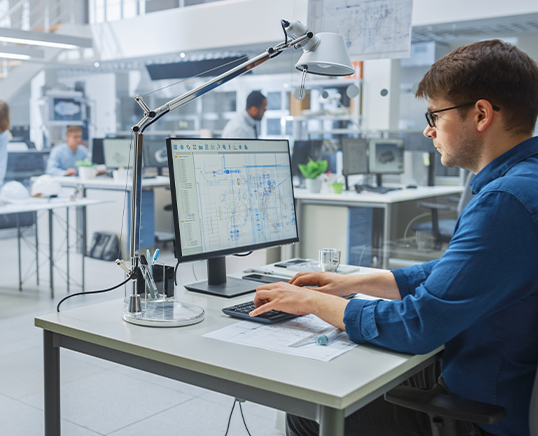 man sat at desk working on computer